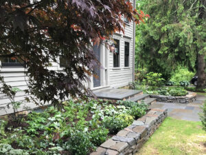 stone wall and patio with plantings trout lily garden design bedford ny